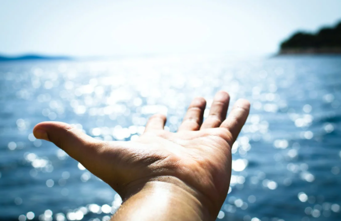 hand extending towards water
